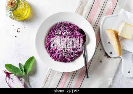 Italienisches Risotto mit Heidelbeeren und roten Zwiebeln mit Käse und Salbei auf dem Tisch Stockfoto