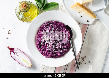 Italienisches Risotto mit Heidelbeeren und roten Zwiebeln mit Käse und Salbei auf dem Tisch Stockfoto