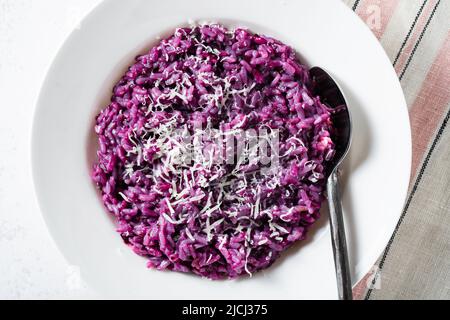 Italienisches Risotto mit Heidelbeeren und roten Zwiebeln mit Käse und Salbei auf dem Tisch Stockfoto