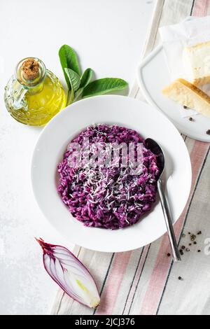 Italienisches Risotto mit Heidelbeeren und roten Zwiebeln mit Käse und Salbei auf dem Tisch Stockfoto