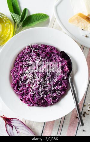 Italienisches Risotto mit Heidelbeeren und roten Zwiebeln mit Käse und Salbei auf dem Tisch Stockfoto