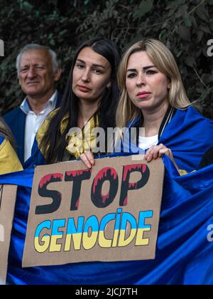 Sofia, Bulgarien, 13. Juni 2022: Zwei Frauen halten ukrainische Flagge und ein Transparent Stop Genocide bei der Demonstration gegen die russische Aggression in Ukra Stockfoto
