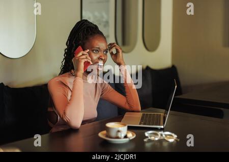 Vertikale wütend, schreiende Mischrasse Frau, Influencer Kaffee trinken, telefonieren, arbeiten online im Café mit Laptop, PC Stockfoto