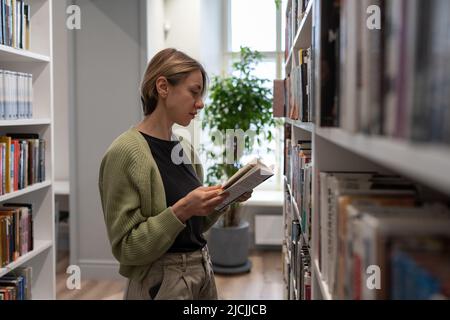 Scandinavian schöne Frau bekommen zweiten Abschluss in der Universitätsbibliothek. Bildung hat keine Altersgrenze Stockfoto
