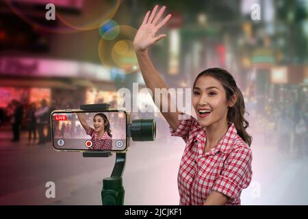 Weibliche Touristen-Bloggerinnen genießen es, Live-Videoclips bei nächtlichen Touristenattraktionen in der Stadt zu drehen. Stockfoto