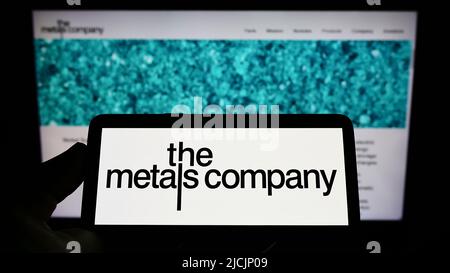 Person mit Smartphone und Logo des Bergbauunternehmens TMC The Metals Company Inc. Auf dem Bildschirm vor der Website. Konzentrieren Sie sich auf die Telefonanzeige. Stockfoto