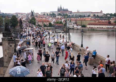 Prag, Tschechische Republik. 05.. Juni 2022. Passanten laufen über die Karlsbrücke vor der Prager Burg. Quelle: Sebastian Kahnert/dpa/Alamy Live News Stockfoto