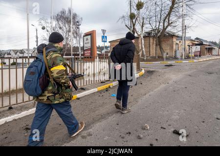 IRPIN, UKRAINE 03. März. Ein Mitglied der Territorialen Verteidigungskräfte zielt mit seinem Gewehr auf einen Mann mit Handschellen, der verdächtigt wird, russischen Streitkräften zu helfen, während die russische Invasion in der Ukraine am 03. März 2022 in Irpin, Ukraine, fortgesetzt wird. Russland begann am 24. Februar 2022 eine militärische Invasion der Ukraine, nachdem das russische parlament Verträge mit zwei abtrünnigen Regionen in der Ostukraine gebilligt hatte. Es ist der größte militärische Konflikt in Europa seit dem Zweiten Weltkrieg Stockfoto