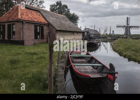 Enkhuizen, Niederlande - August 18,2021: Die Häuser, Windmühle und Boot am Kanal im traditionellen alten Fischerdorf Freilichtmuseum von Zuider Stockfoto