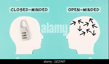 Silhouette von zwei Menschen, ein Mann ist verschlossen mit einem Schloss in seinem Kopf, im Gegensatz zu der Person mit dem offenen Gehirn, andere Denkweise Stockfoto