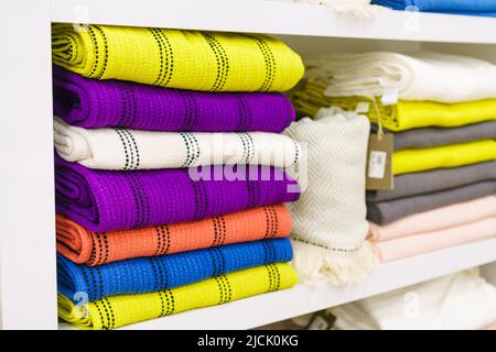 Mehrfarbige Handtücher im Regal auf dem Markt, Verkauf Baumwollhandtücher, Stapel farbige Baumwollhandtücher, ein Regal in der heimischen Reihe des Marktes, Nahaufnahme selektiven Fokus Stockfoto