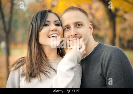 Freundliches Porträt der asiatischen jungen schönen jungen Frau und jungen kaukasischen Mann im Herbst im Freien Stockfoto