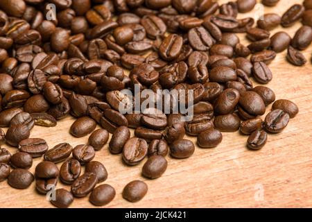 Nahaufnahme von Kaffeebohnen auf einem Holztisch Stockfoto