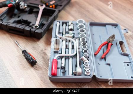 Box mit Elektroinstallateur auf Holzhintergrund. Stockfoto