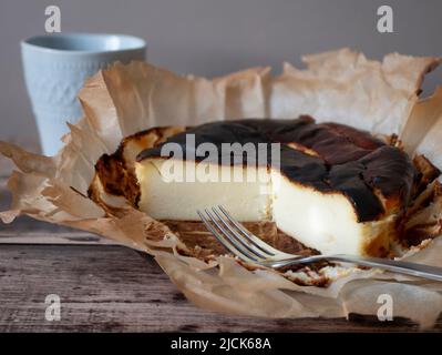 Gebrannter Käsekuchen im baskischen Stil mit verbrannter Kruste und cremigem, aber leichtem Zentrum. Ungewöhnlicher Käsekuchen, selektiver Fokus Stockfoto