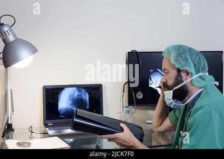 Im medizinischen Labor wird der Patient unter Aufsicht eines Radiologen einer MRT- oder CT-Untersuchung unterziehen, im Kontrollraum beobachtet der Arzt Stockfoto