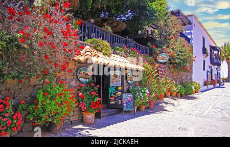 Betancuria, Fuerteventura - Juin 14. 2019: Wunderschönes romantisches Restaurantgebäude, Dachterrasse, bunte Blumen in Tontöpfen, leere Straße Stockfoto