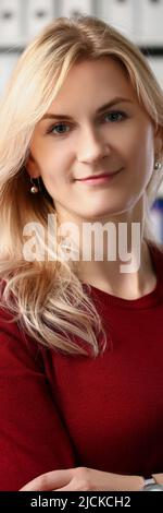 Vorzeigbarer Büroangestellter lächelt und posiert mit gekreuzten Armen für Bilder Stockfoto