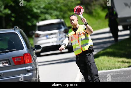 Griesen, Deutschland. 14.. Juni 2022. Ein Bundespolizist kontrolliert den Verkehr an der Grenze auf der B 23 in Griesen. Der Gipfel G7 ist für den 26. Und 28. Juni 2022 auf Schloss Elmau geplant. Quelle: Angelika Warmuth/dpa/Alamy Live News Stockfoto