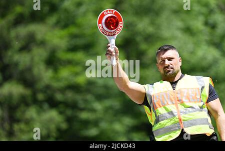 Griesen, Deutschland. 14.. Juni 2022. Ein Bundespolizist kontrolliert den Verkehr an der Grenze auf der B 23 in Griesen. Der Gipfel G7 ist für den 26. Und 28. Juni 2022 auf Schloss Elmau geplant. Quelle: Angelika Warmuth/dpa/Alamy Live News Stockfoto