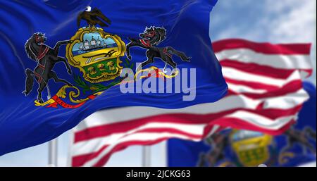 Die Staatsflagge von Pennsylvania winkt zusammen mit der Nationalflagge der Vereinigten Staaten von Amerika. Im Hintergrund ist der Himmel klar. Pennsylvania Stockfoto