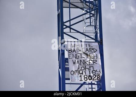 Salford, Großbritannien, 14.. Juni 2022. Seit Anfang des 13.. Juni protestiert ein Mann auf einem Kran in der Chapel Street in Salford, Greater Manchester, England, Großbritannien. Das Foto wurde am Morgen des 14.. Juni aufgenommen, etwa 29 Stunden nach dem Protest. Mehrere Protestbanner sind auf dem Kran. Quelle: Terry Waller/Alamy Live News Stockfoto