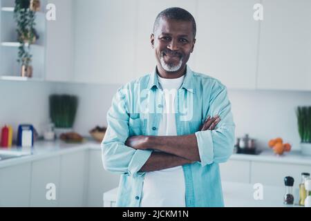 Foto von optimistischen erfolgreichen gealterten Mann Manager überqueren Arme stehen in der modernen Küche Verkauf Wohnung Stockfoto