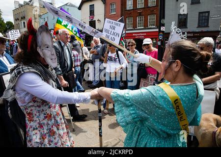 Windsor, Großbritannien. 13.. Juni 2022. Maskierte Aktivisten der Stop the war Coalition führen die Kämpfe von Sir Anthony Blair während eines Protestes vor Windsor Castle gegen die Verleihung der Ehre an den ehemaligen Premierminister aus, der ihrer Meinung nach aufgrund seiner umstrittenen Rolle in der für Kriegsverbrechen zur Verantwortung gezogen werden sollte Irakkrieg. Sir Anthony Blair wurde letzte Woche bei einer privaten Audienz bei der Königin zum Ritter geschlagen und wird während einer Zeremonie im Schloss Windsor als Mitglied des Kleiderordens eingesetzt. Kredit: Mark Kerrison/Alamy Live Nachrichten Stockfoto