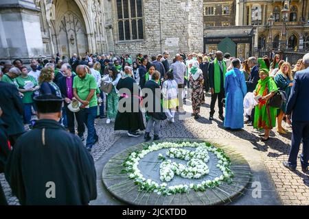 London, Großbritannien. 14.. Juni 2022. Mitglieder der Gemeinde Grenfell und Trauernde legen Blumen. Trauernde und Geistliche verlassen Westminster Abbey nach der Gedenkfeier zum 5.. Jahrestag des Brandes im Greenfell Tower. Zur Erinnerung an die Opfer werden weiße Rosen gelegt. Der Gottesdienst wird von trauernden Familien und Freunden, an der Rettungsaktion beteiligten Personen und vielen anderen, darunter der ehemaligen Premierministerin Theresa May und dem Bürgermeister von London Sadiq Khan, besucht. Kredit: Imageplotter/Alamy Live Nachrichten Stockfoto