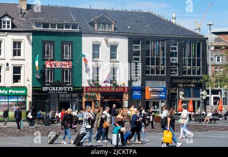 Tourist mit rollendem Gepäck an den Alfresco-Bars am Williamson Square, Liverpool Stockfoto