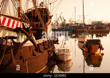 Großbritannien, England, Devon, Torbay, Brixham Harbour, Replik der berühmten Golden Hind Galeone in voller Größe mit verankerten Booten bei Dawn Stockfoto