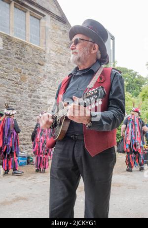 Flagcrackers' Musiker unterstützt die Craven Border Morris-Seite in farbenfrohen Stoffjacken und tanzt beim Open Farm Day in Kappelside in Rathmell. Stockfoto