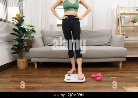 Gesund und Gewichtsverlust Konzept, junge asiatische Frau Schritt auf Waage nach der Gewichtskontrolle. Stockfoto