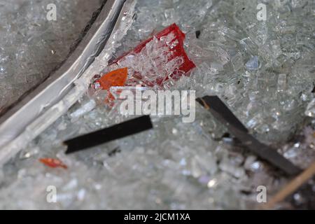 Düsseldorf, Deutschland. 14.. Juni 2022. Defekte Schlussleuchten liegen zwischen zerbrochenem Glas im Laden. Unbekannte haben am Dienstagabend aus einem Geschäft in der Düsseldorfer Königsallee mehrere Luxusuhren gestohlen. Nach Angaben der Polizei fuhren sie ein gestohlenes Auto mehrere Male rückwärts gegen die Tür eines Seiteneingangs und in ein Schaufenster. Dadurch brach das Fenster, so dass sie den Uhrenladen betreten konnten. Sie nahmen mehrere Uhren aus einer Vitrine und flohen mit dem Auto. Kredit: David Young/dpa/Alamy Live Nachrichten Stockfoto