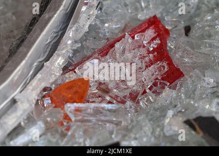 Düsseldorf, Deutschland. 14.. Juni 2022. Defekte Schlussleuchten liegen zwischen zerbrochenem Glas im Laden. Unbekannte haben am Dienstagabend aus einem Geschäft in der Düsseldorfer Königsallee mehrere Luxusuhren gestohlen. Nach Angaben der Polizei fuhren sie ein gestohlenes Auto mehrere Male rückwärts gegen die Tür eines Seiteneingangs und in ein Schaufenster. Dadurch brach das Fenster, so dass sie den Uhrenladen betreten konnten. Sie nahmen mehrere Uhren aus einer Vitrine und flohen mit dem Auto. Kredit: David Young/dpa/Alamy Live Nachrichten Stockfoto