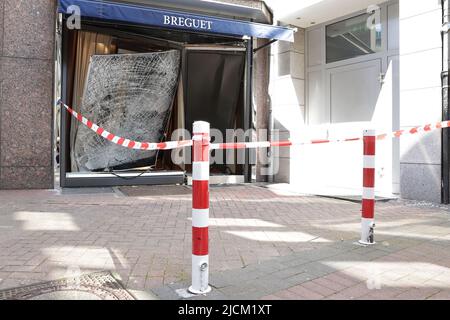 Düsseldorf, Deutschland. 14.. Juni 2022. Das eingeschobene Fenster und die Tür sind mit einem Absperrband an einem Lager gesichert. Unbekannte haben am Dienstagabend mehrere Luxusuhren aus einem Geschäft in der Düsseldorfer Königsallee gestohlen. Nach Angaben der Polizei fuhren sie ein gestohlenes Auto mehrere Male rückwärts gegen die Tür eines Seiteneingangs und in ein Schaufenster. Dadurch brach das Fenster, so dass sie den Uhrenladen betreten konnten. Sie nahmen mehrere Uhren aus einer Vitrine und flohen mit dem Auto. Kredit: David Young/dpa/Alamy Live Nachrichten Stockfoto