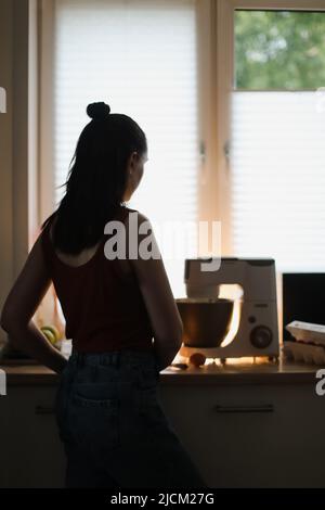 Hausfrau Frau Backen zu Hause mit Küche Planetenmischer in einer gemütlichen Küche Stockfoto