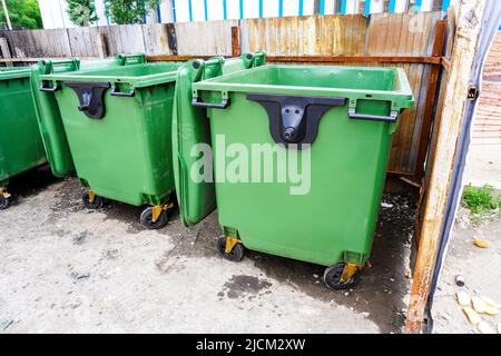 Geöffnete grüne Kunststoff-Recycling-Behälter an der Stadtstraße Stockfoto