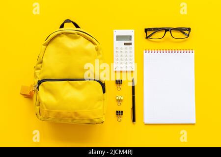 Flacher Schulrucksack mit Schulartikeln und Schülerzubehör, Draufsicht Stockfoto
