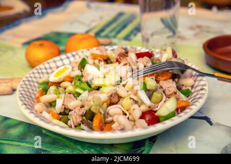 Blick auf den weißen Teller mit gemischtem Salat mit weißen Bohnen und Thunfisch Stockfoto