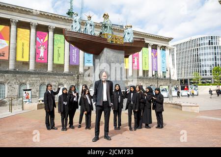 Ein großes öffentliches Kunstwerk, in dem der berühmte guyanesisch-britische Künstler Hew Locke die Skulptur der Königin Victoria im Stadtzentrum von Birmingham neu gestaltet. Das Projekt wurde von der Ikon Gallery für das Birmingham 2022 Festival (das Kulturprogramm der Commonwealth Games) in Auftrag gegeben. Das spektakuläre Werk mit dem Titel Foreign Exchange wird Lockes erste temporäre öffentliche Skulptur sein. Im Bild Hew Locke mit Schülern der Small Heath Academy. Stockfoto