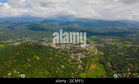 Eine Stadt und landwirtschaftliche Felder in einem Bergtal zwischen den Bergen. Gampola Town, Sri Lanka. Stockfoto