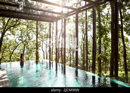 Eine Frau wat im Pool der Ganga Pool Villa in Ananda im Himalaya, Indien. Stockfoto