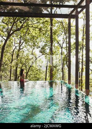 Eine Frau wat im Pool der Ganga Pool Villa in Ananda im Himalaya, Indien. Stockfoto