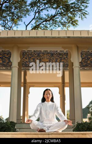 Eine junge Frau praktiziert am frühen Morgen Meditation. Stockfoto