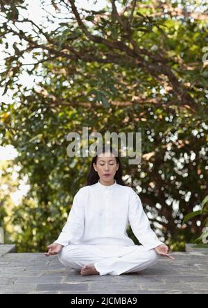 Eine junge Frau praktiziert am frühen Morgen Meditation. Stockfoto