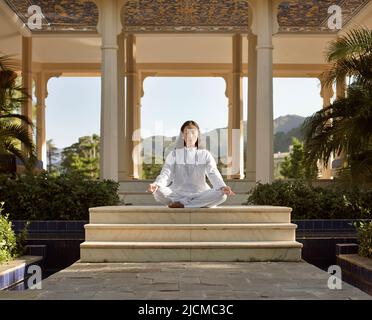 Eine junge Frau praktiziert am frühen Morgen Meditation. Stockfoto