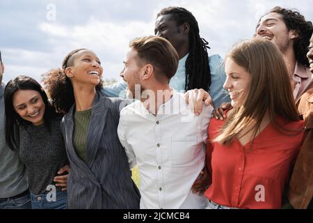 Multiethnische Gruppe von Freunden, die gemeinsam im Freien Spaß haben - Millennial-Freunde, die draußen gemeinsam lachen Stockfoto