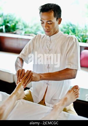 Balinesischer Spa-Therapeut mit Fußrefloxologie im Ayung Spa, Ubud Hanging Gardens, Bali, Indonesien. Stockfoto