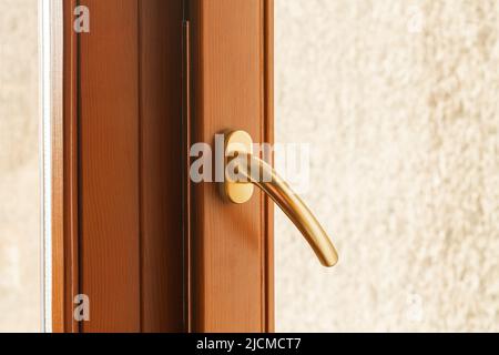 Fenstergriff aus Metall in goldener Nahaufnahme Stockfoto